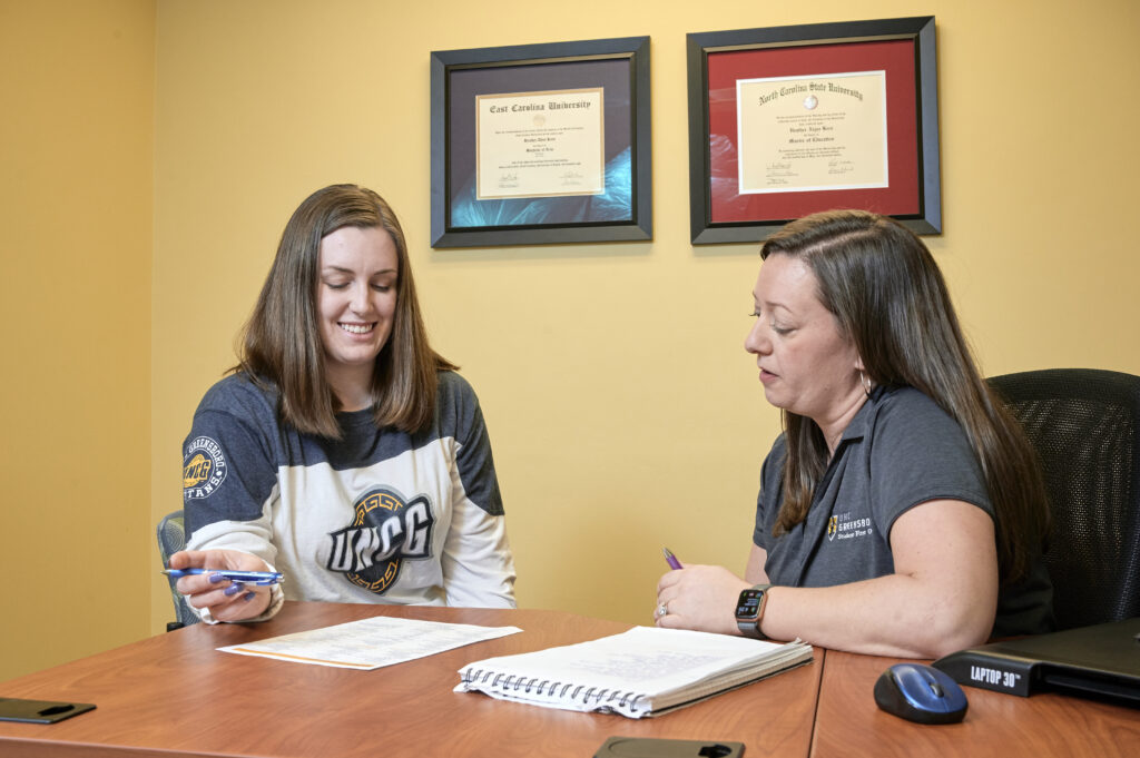 Staff and Student sitting at a desk